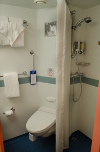 The bathroom of my Category 8C Balcony Stateroom features a toilet, shower…Photo © 2015 Aaron Saunders