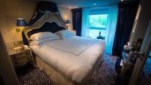 Stateroom 425 measures 194 square feet with an open-air balcony and custom made-to-order English Savoir beds draped in monogrammed bed linens. © 2015 Ralph Grizzle