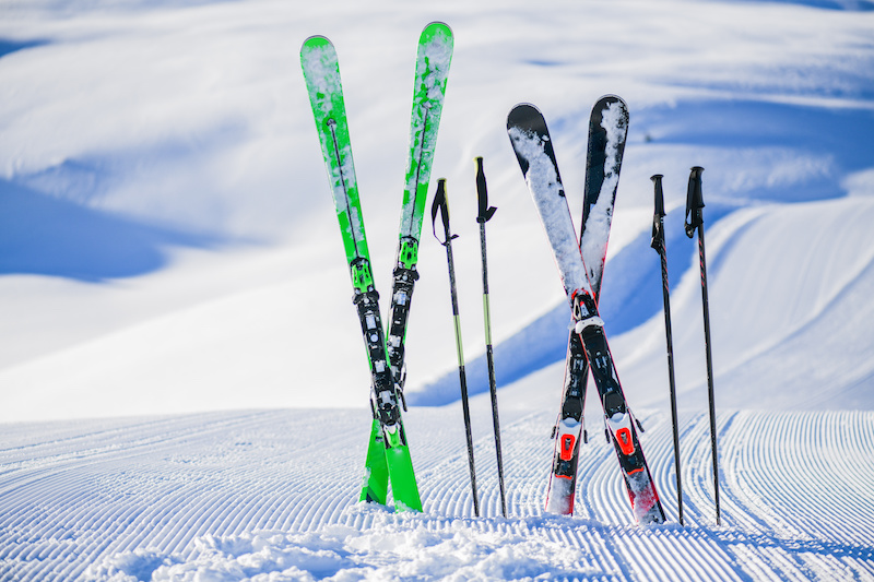 Skis in snow in winter season, mountains and ski items or equipments on the top in dolomites,