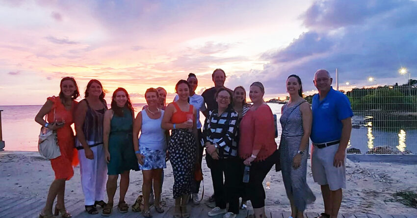 group picture of travel industry professionals at beach sunset