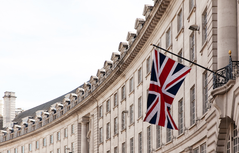 British flag on the background of the historic building of London, UK